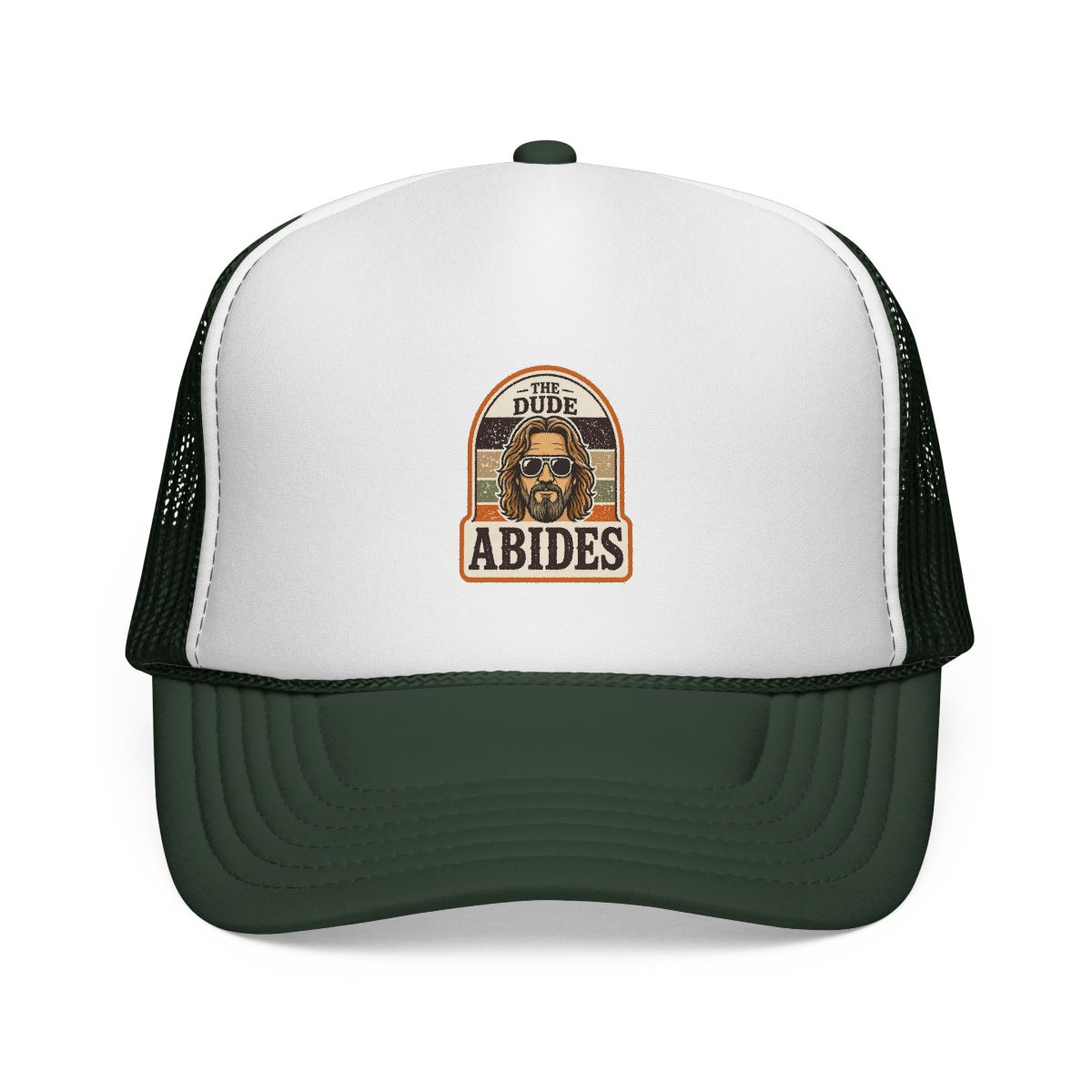 A brown and white trucker hat with a patch that says "The Dude Abides" and features a cartoon image of a man wearing sunglasses