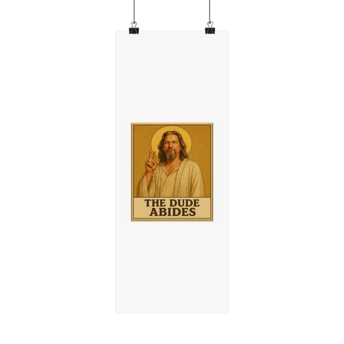 Framed poster depicting a man with long hair and a beard, dressed in a robe, giving a peace sign. A golden halo is behind him. The text "THE DUDE ABIDES" is at the bottom of the poster - alternate angle 2, merchandise