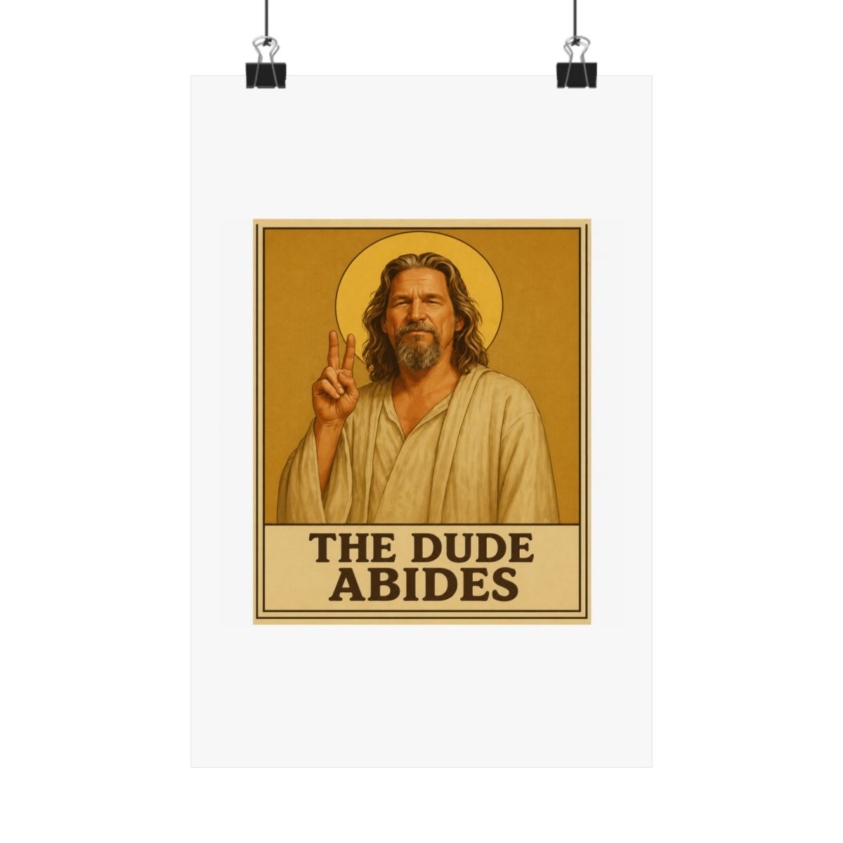 Framed poster depicting a man with long hair and a beard, dressed in a robe, giving a peace sign. A golden halo is behind him. The text "THE DUDE ABIDES" is at the bottom of the poster - alternate angle 1, merchandise